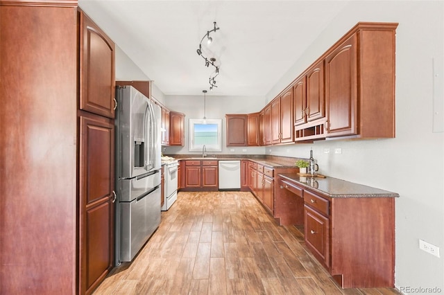 224 Lakeview Forest Hts, Florissant, CO 80816 - kitchen featuring white appliances, a sink, light wood-style floors, dark countertops, and brown cabinets