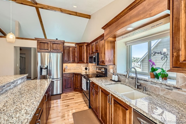 kitchen featuring light wood-type flooring, appliances with stainless steel finishes, a sink, vaulted ceiling with beams, and backsplash
