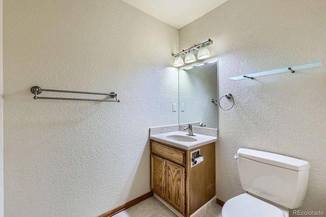 bathroom with toilet, tile patterned floors, and vanity