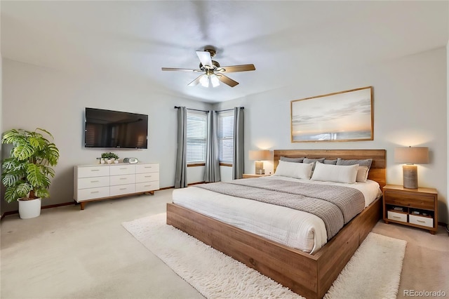 bedroom with light colored carpet, ceiling fan, and baseboards