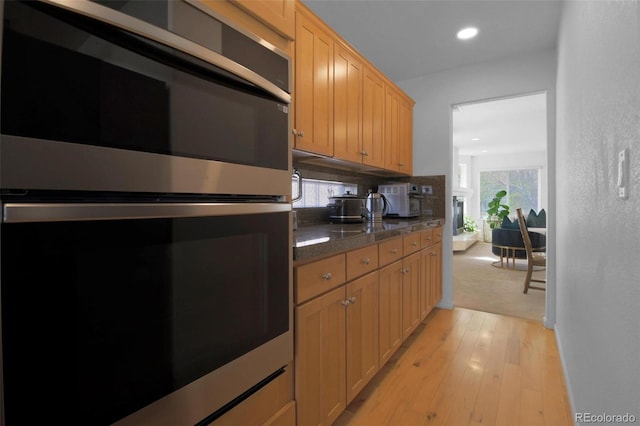 21229 E 50th Ave, Denver, CO 80249 - kitchen featuring recessed lighting, stainless steel double oven, light wood-style floors, dark countertops, and tasteful backsplash