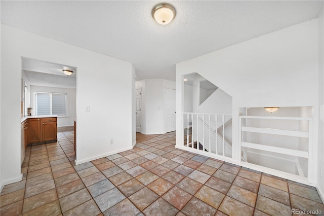 4064 S Himalaya Way, Aurora, CO 80013 - empty room featuring a textured ceiling, light stone finish flooring, and built in shelves