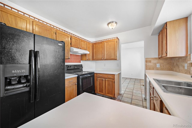 4064 S Himalaya Way, Aurora, CO 80013 - kitchen with black appliances, under cabinet range hood, decorative backsplash, light countertops, and brown cabinets