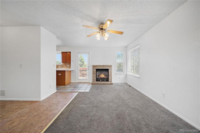 4064 S Himalaya Way, Aurora, CO 80013 - unfurnished living room featuring a textured ceiling, a ceiling fan, light colored carpet, and a brick fireplace