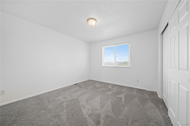 4064 S Himalaya Way, Aurora, CO 80013 - unfurnished bedroom featuring a closet, carpet flooring, and a textured ceiling