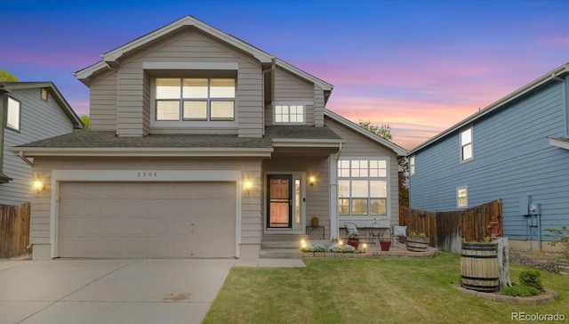 traditional-style home featuring fence, a shingled roof, a garage, a front yard, and driveway