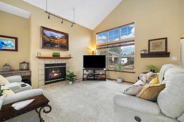 living room featuring carpet flooring, high vaulted ceiling, baseboards, and a tile fireplace