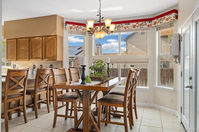 dining room featuring light tile patterned floors, a notable chandelier, and a healthy amount of sunlight