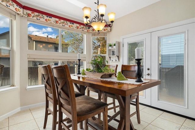 dining space with an inviting chandelier, baseboards, and light tile patterned floors