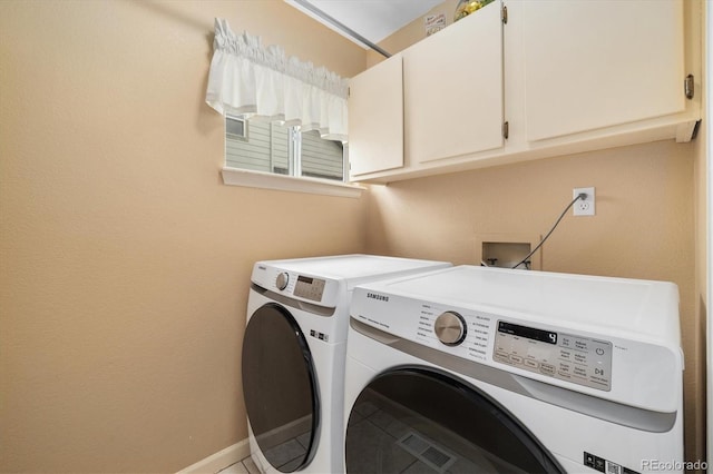 laundry room with washer and clothes dryer and cabinet space