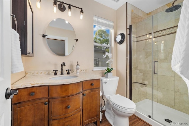 full bath featuring toilet, a shower stall, wood finished floors, and vanity