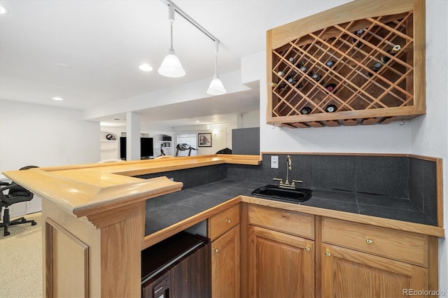 bar with indoor wet bar, a sink, and pendant lighting