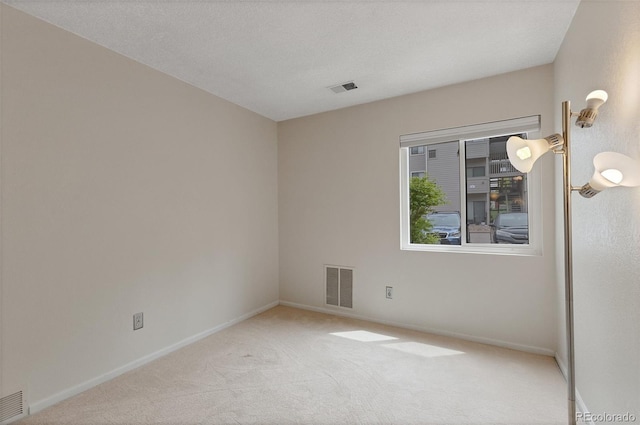 carpeted spare room featuring a textured ceiling