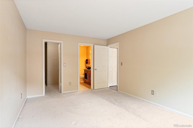 unfurnished bedroom featuring carpet, connected bathroom, a closet, and a walk in closet