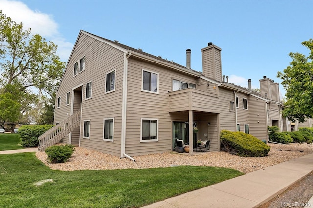 view of front of home with a balcony and a front yard