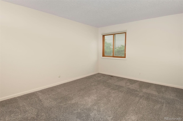 6505 Kalua Rd Unit 104B, Boulder, CO 80301 - empty room featuring dark colored carpet, baseboards, and a textured ceiling