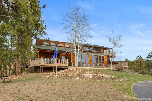 rear view of property featuring a wooden deck