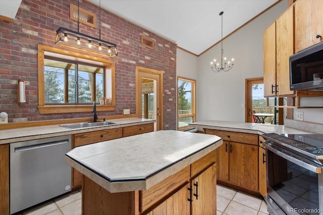 kitchen with light tile patterned floors, a sink, high vaulted ceiling, tile counters, and appliances with stainless steel finishes