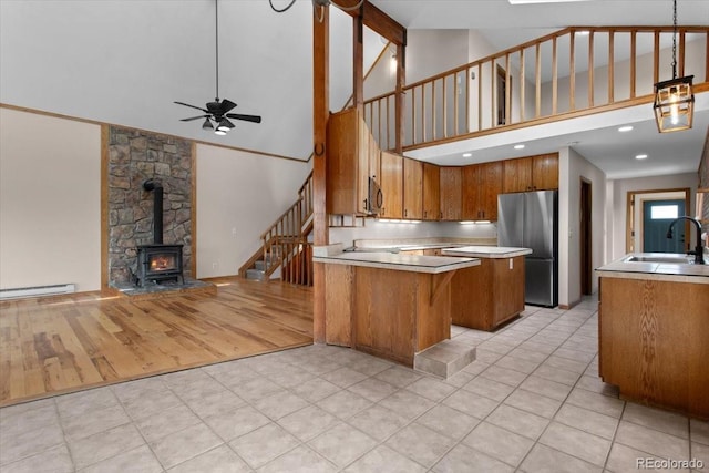 kitchen with brown cabinets, open floor plan, appliances with stainless steel finishes, and a sink