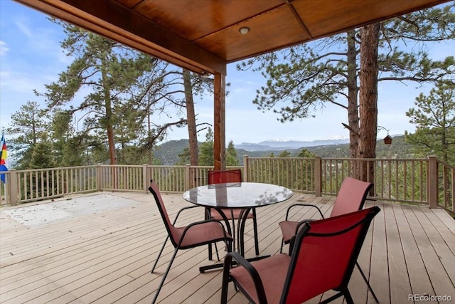 deck with outdoor dining space and a mountain view