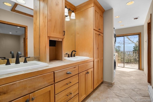 full bathroom featuring a sink, double vanity, baseboards, and stone finish flooring