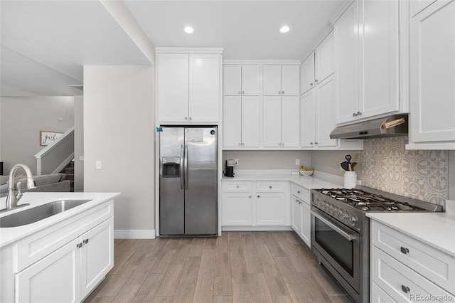 12214 Stone Timber Ct, Parker, CO 80134 - kitchen with appliances with stainless steel finishes, under cabinet range hood, light wood-style flooring, light countertops, and recessed lighting
