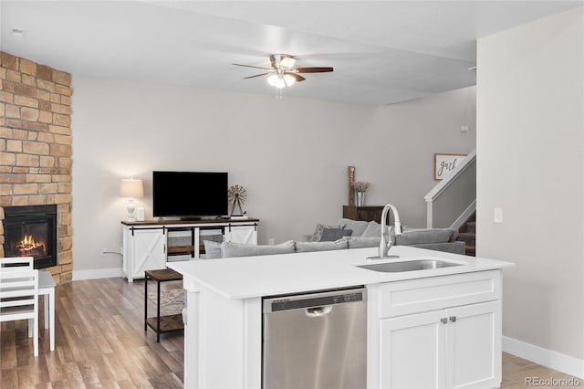 12214 Stone Timber Ct, Parker, CO 80134 - kitchen featuring dishwasher, open floor plan, ceiling fan, a brick fireplace, and white cabinets