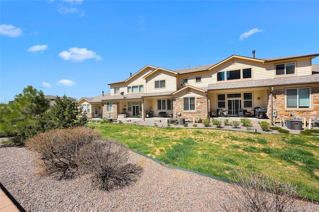 12214 Stone Timber Ct, Parker, CO 80134 - back of house featuring stone siding, a patio area, and a yard