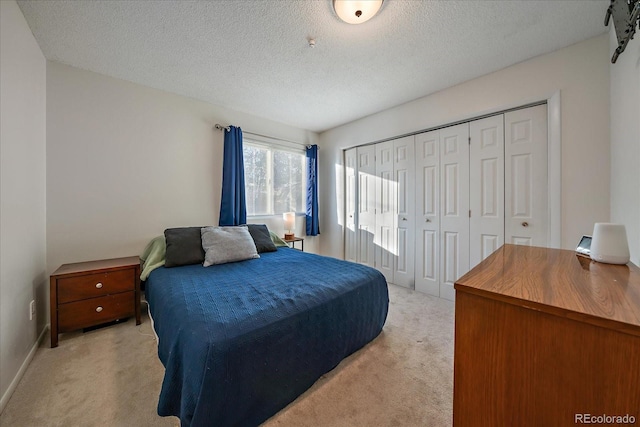 carpeted bedroom featuring a textured ceiling and a closet