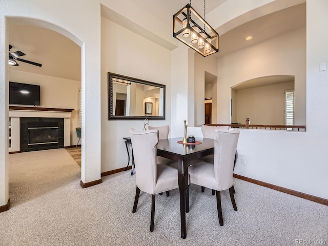 10050 Eagle Valley Way, Highlands Ranch, CO 80129 - carpeted dining room featuring arched walkways, a ceiling fan, and a tiled fireplace