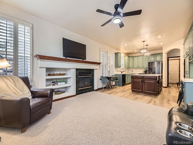 10050 Eagle Valley Way, Highlands Ranch, CO 80129 - living room featuring a ceiling fan, a tile fireplace, light wood-type flooring, and recessed lighting