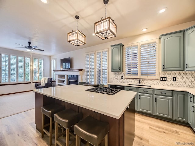 10050 Eagle Valley Way, Highlands Ranch, CO 80129 - kitchen with gas cooktop, a kitchen island, decorative backsplash, a ceiling fan, and open floor plan