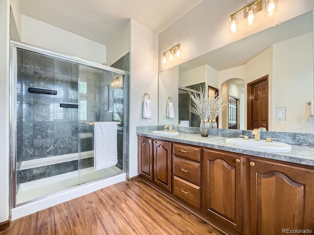 10050 Eagle Valley Way, Highlands Ranch, CO 80129 - bathroom featuring double vanity, a shower stall, and wood finished floors
