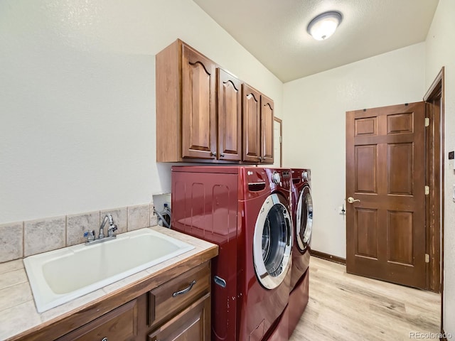 10050 Eagle Valley Way, Highlands Ranch, CO 80129 - washroom with cabinet space, light wood-style flooring, and washing machine and dryer