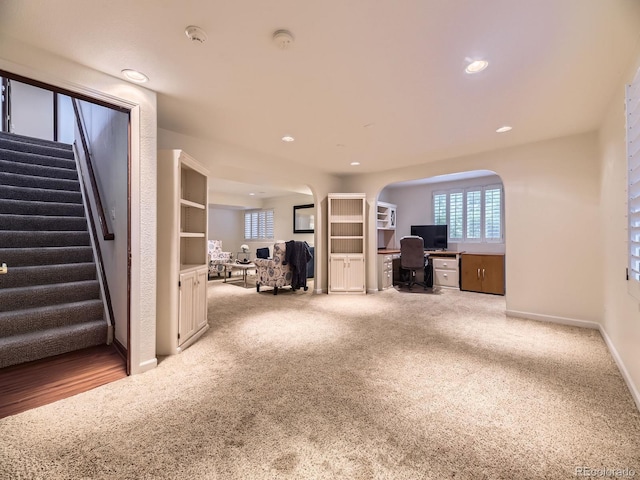10050 Eagle Valley Way, Highlands Ranch, CO 80129 - unfurnished living room with arched walkways, carpet flooring, stairs, an office area, and recessed lighting