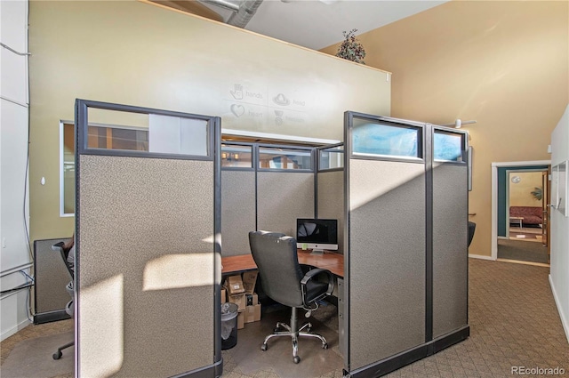 office with light carpet and a towering ceiling