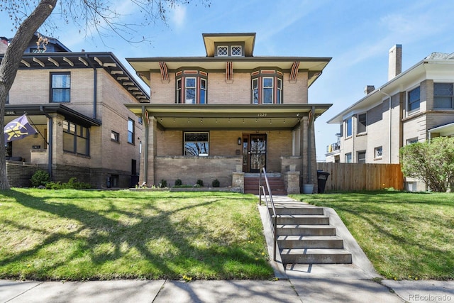 view of front of property with brick siding, fence, and a front lawn