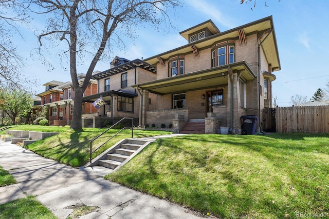 view of front of property with fence, a front lawn, and brick siding