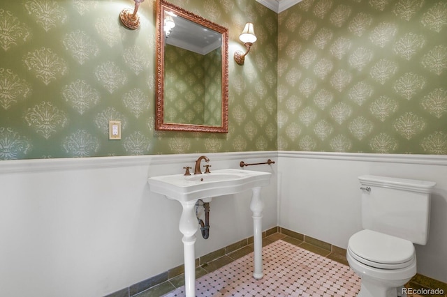 bathroom featuring toilet, wallpapered walls, a wainscoted wall, and tile patterned flooring