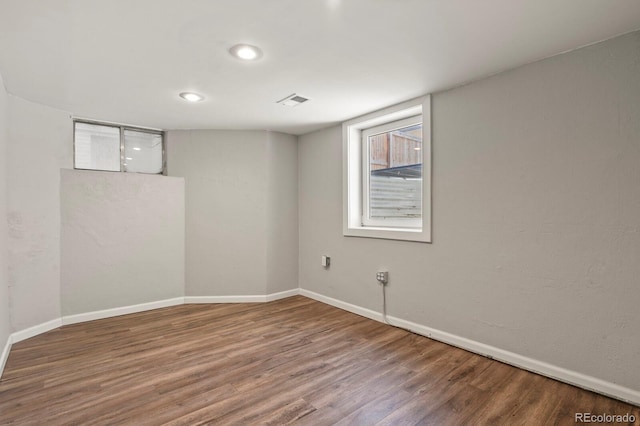 finished below grade area featuring recessed lighting, visible vents, baseboards, and wood finished floors
