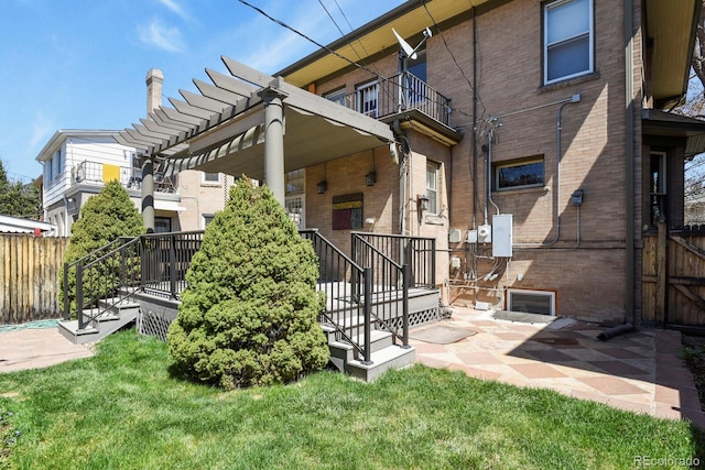 exterior space with a yard, a pergola, fence, and brick siding