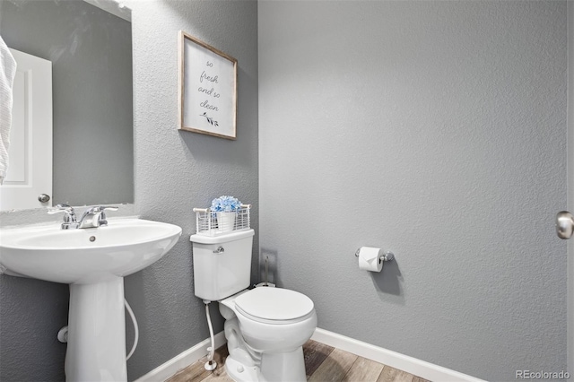 bathroom with sink, hardwood / wood-style floors, and toilet