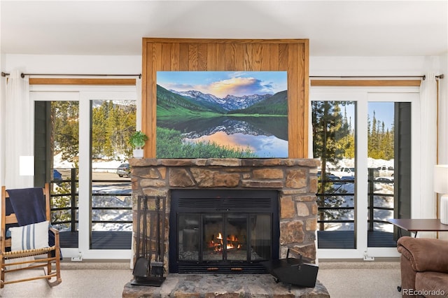 interior details featuring carpet floors and a stone fireplace