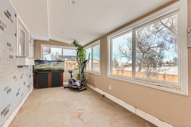 unfurnished sunroom featuring vaulted ceiling and a wealth of natural light