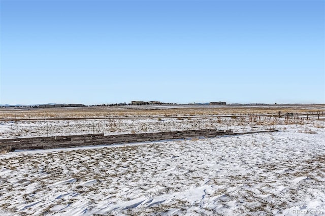 snowy yard featuring a rural view