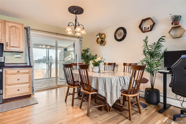 dining area featuring a baseboard heating unit, a chandelier, and light hardwood / wood-style flooring