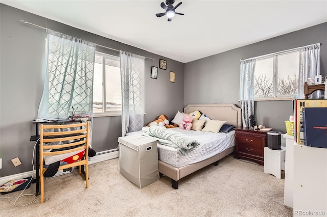 carpeted bedroom featuring multiple windows, a baseboard radiator, and ceiling fan