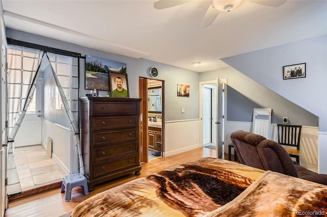 bedroom with light hardwood / wood-style flooring, ceiling fan, and ensuite bathroom