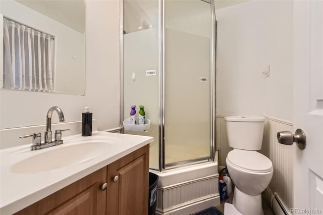 bathroom featuring vanity, toilet, baseboard heating, and a shower with shower door