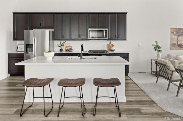 12547 Lake View St, Longmont, CO 80504 - kitchen featuring appliances with stainless steel finishes, a sink, a breakfast bar area, light countertops, and baseboards